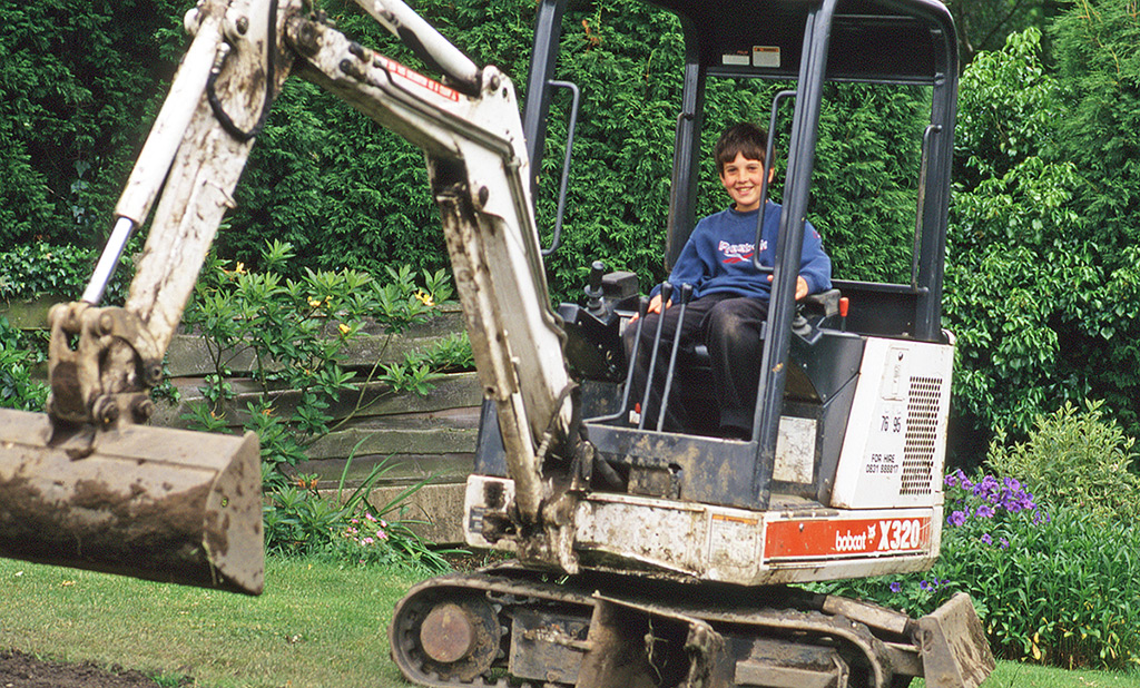 Nick on Dave Rimmer's Bobcat doing some landscaping in our garden